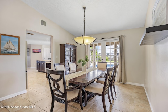 tiled dining room with french doors and lofted ceiling