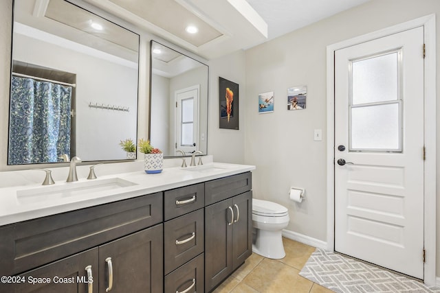 bathroom with vanity, a healthy amount of sunlight, tile patterned floors, and toilet