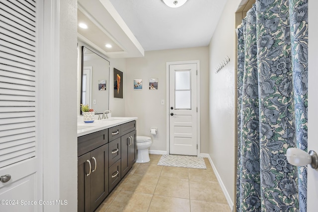 bathroom with tile patterned flooring, vanity, and toilet