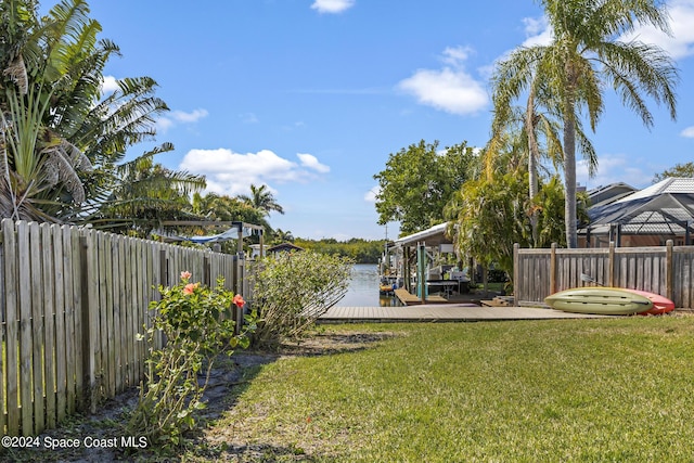 view of yard with a water view and a dock