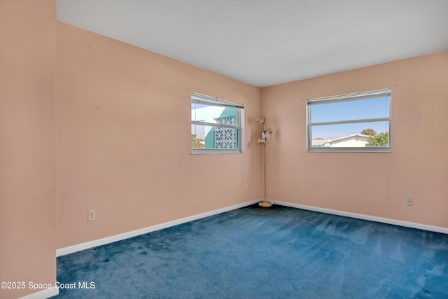 spare room featuring dark carpet