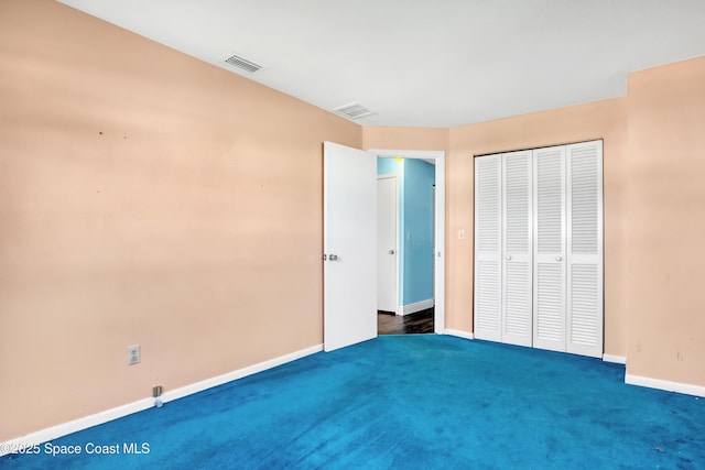 unfurnished bedroom featuring dark carpet and a closet