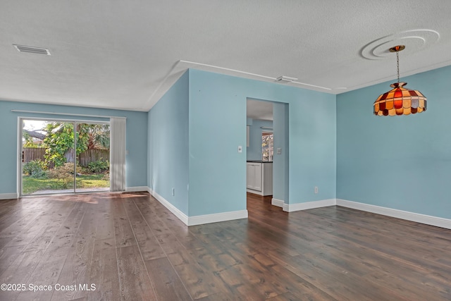 spare room with dark wood-type flooring and a textured ceiling