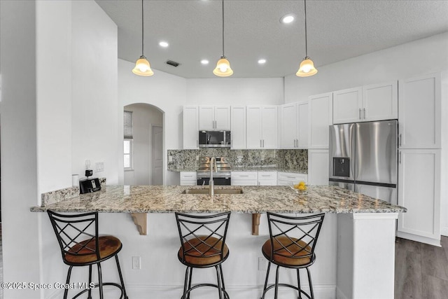 kitchen with white cabinetry, kitchen peninsula, and appliances with stainless steel finishes