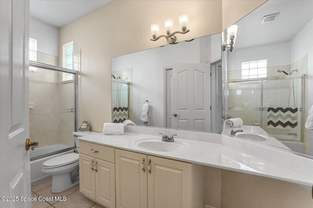 full bathroom with tile patterned flooring, vanity, enclosed tub / shower combo, and toilet