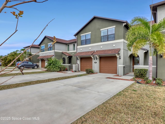 view of front of home featuring stucco siding, an attached garage, a gate, and driveway