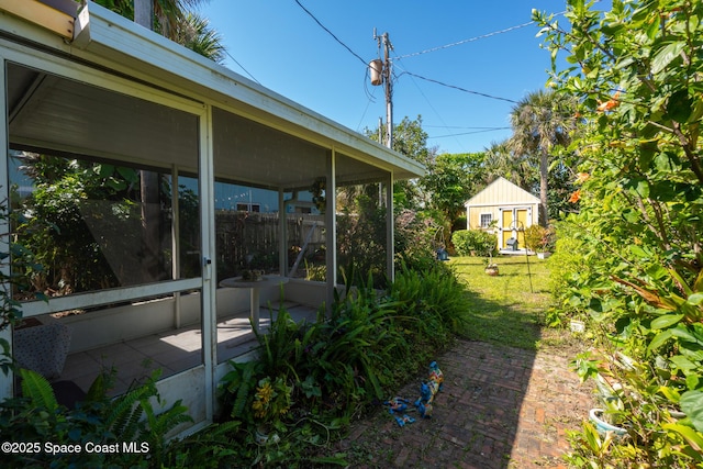 view of yard featuring an outbuilding and a sunroom