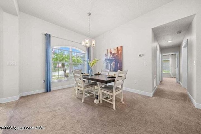 carpeted dining space with a notable chandelier and a textured ceiling