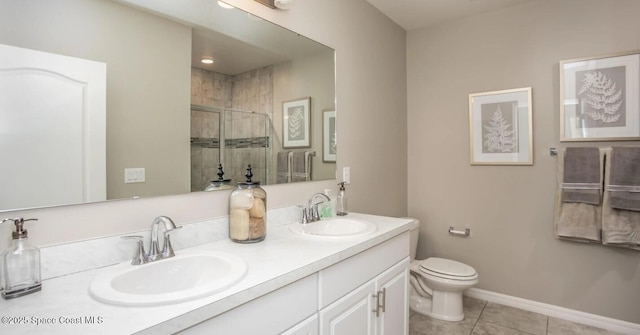 bathroom with tile patterned flooring, vanity, a shower with door, and toilet