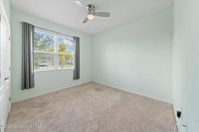 carpeted empty room featuring baseboards and a ceiling fan