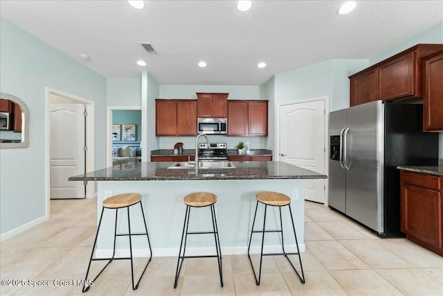kitchen featuring visible vents, a breakfast bar, a sink, and appliances with stainless steel finishes