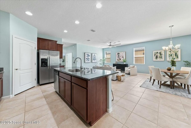 kitchen featuring a sink, an island with sink, light tile patterned flooring, and stainless steel appliances