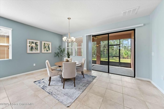dining area featuring baseboards, an inviting chandelier, light tile patterned floors, a textured ceiling, and visible vents