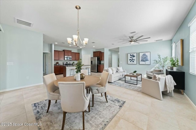 dining space featuring light tile patterned floors, visible vents, ceiling fan with notable chandelier, and baseboards