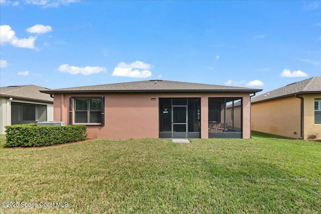 back of property featuring a sunroom, stucco siding, and a lawn