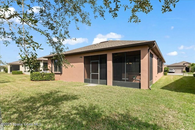 back of house with a sunroom, a lawn, and stucco siding