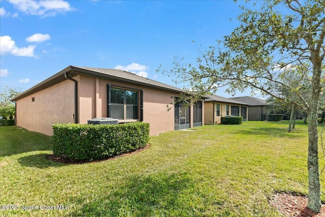 rear view of property with stucco siding and a lawn