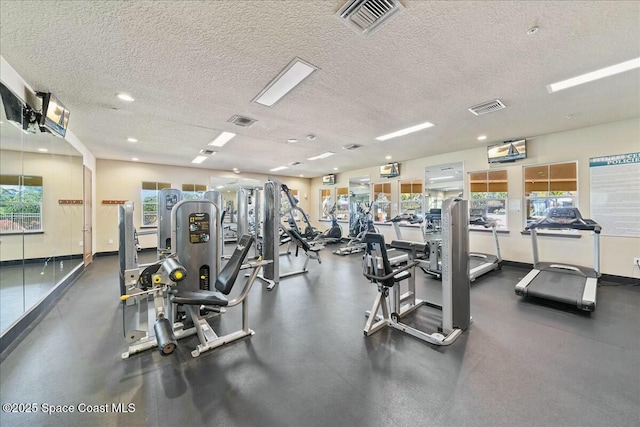 exercise room with visible vents and a textured ceiling