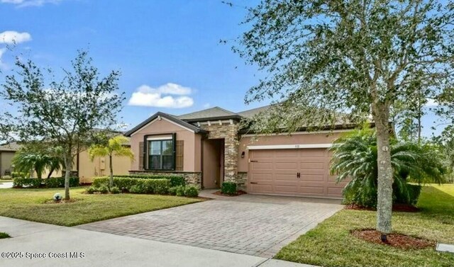 ranch-style house with stucco siding, stone siding, a front lawn, a garage, and driveway