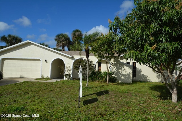 view of front facade featuring a garage, driveway, a front lawn, and stucco siding