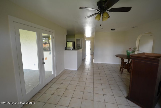 hallway with light tile patterned floors, baseboards, and french doors