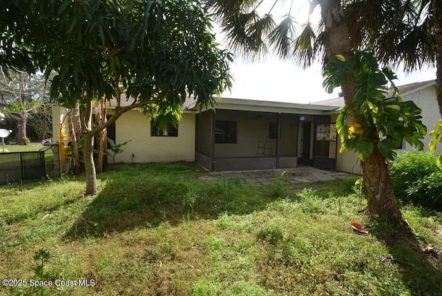 back of house featuring a patio area, a yard, fence, and stucco siding