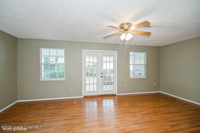 empty room with light wood-type flooring, baseboards, and french doors