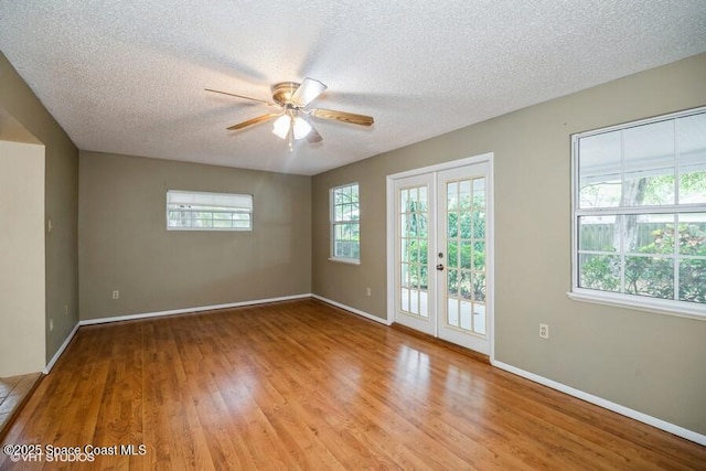 unfurnished room featuring french doors, baseboards, light wood-style floors, and a ceiling fan