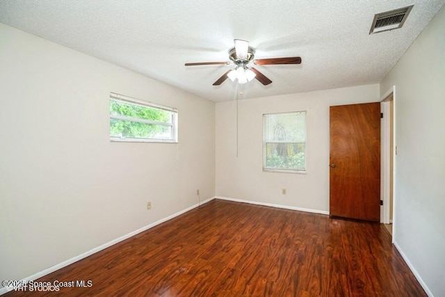 spare room with visible vents, baseboards, wood finished floors, a textured ceiling, and a ceiling fan