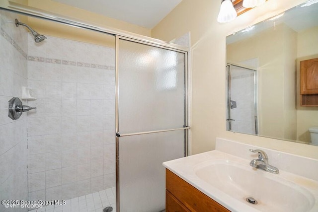 bathroom with vanity, toilet, and a stall shower