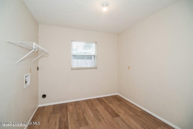 clothes washing area featuring baseboards, washer hookup, laundry area, wood finished floors, and electric dryer hookup