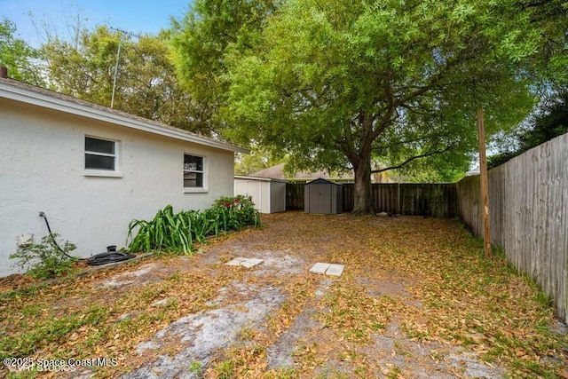 view of yard featuring an outdoor structure, a storage unit, and a fenced backyard