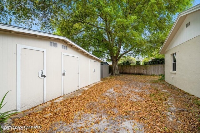 view of yard featuring an outdoor structure and fence