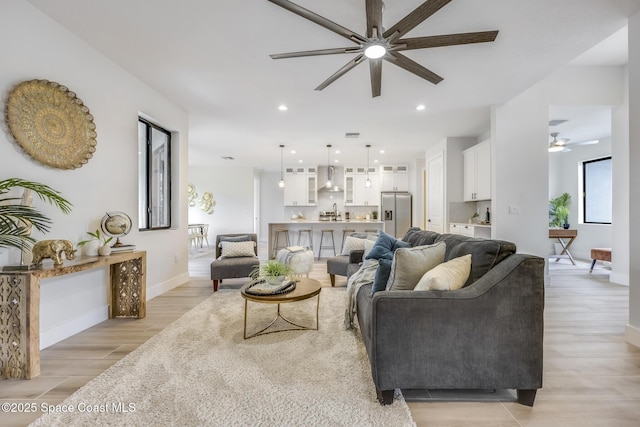 living room with ceiling fan and light hardwood / wood-style floors