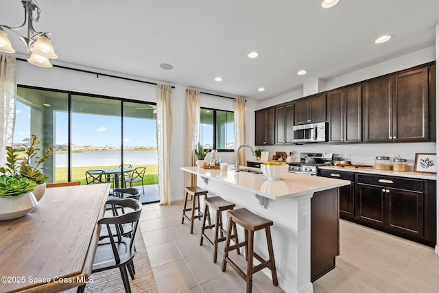 2496 Kamin Dr S, Melbourne, FL 32940 - kitchen with sink, hanging light fixtures, stainless steel appliances, a water view, and a center island with sink