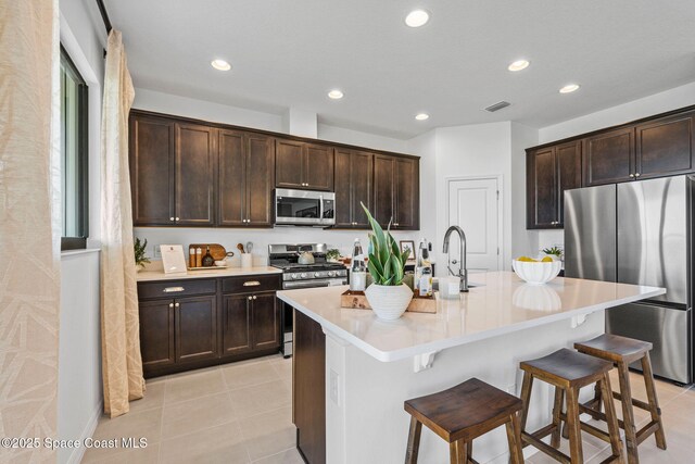2496 Kamin Dr S, Melbourne, FL 32940 - kitchen featuring appliances with stainless steel finishes, a kitchen breakfast bar, sink, and a center island with sink