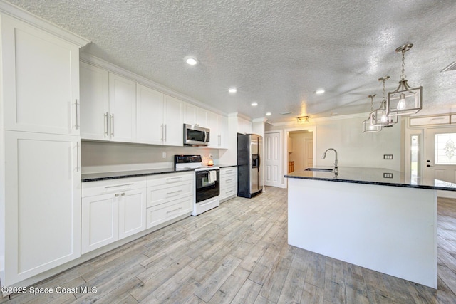 kitchen featuring pendant lighting, crown molding, white cabinetry, stainless steel appliances, and light wood-type flooring