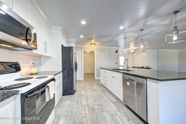 kitchen with sink, white cabinetry, hanging light fixtures, a kitchen island with sink, and stainless steel appliances