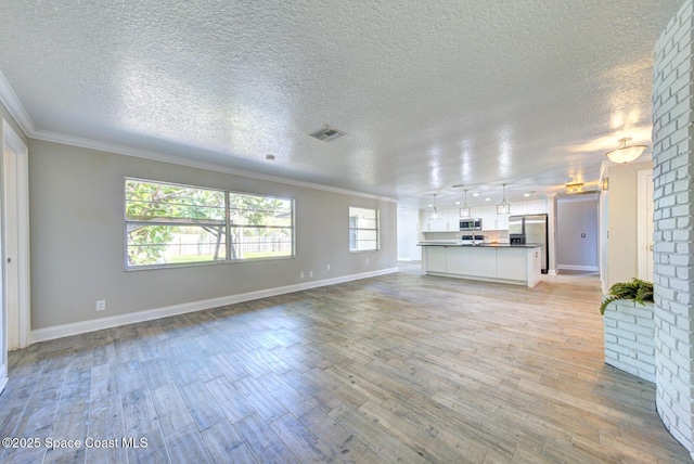 unfurnished living room with ornamental molding, light hardwood / wood-style floors, and a textured ceiling