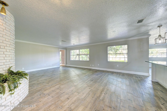 unfurnished living room featuring crown molding, a textured ceiling, and light wood-type flooring