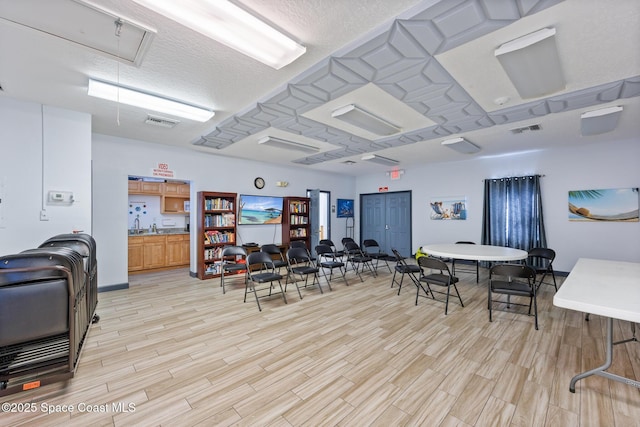 interior space with a textured ceiling and light wood-type flooring