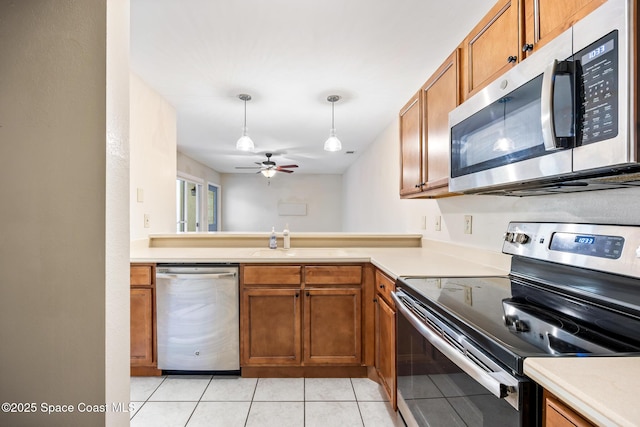 kitchen featuring sink, ceiling fan, hanging light fixtures, stainless steel appliances, and light tile patterned flooring