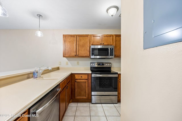 kitchen with sink, light tile patterned floors, electric panel, pendant lighting, and stainless steel appliances