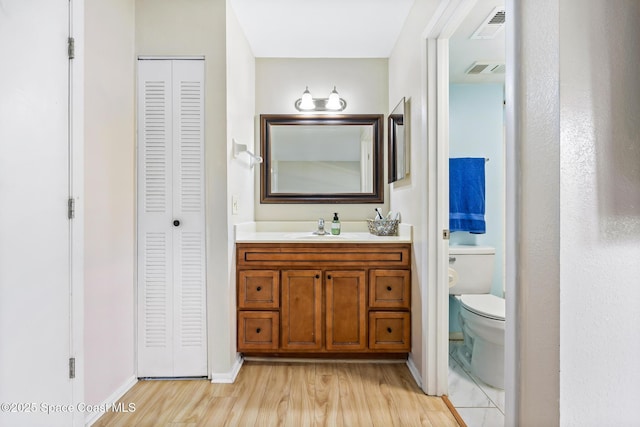 bathroom featuring vanity, hardwood / wood-style floors, and toilet