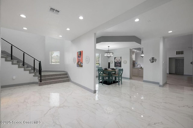 foyer entrance featuring a chandelier and sink