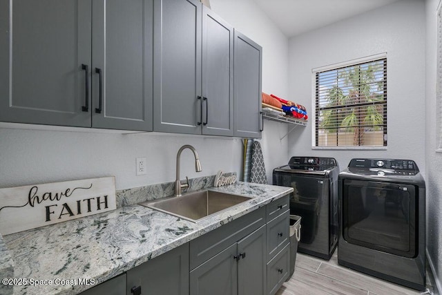 laundry room with cabinets, independent washer and dryer, and sink