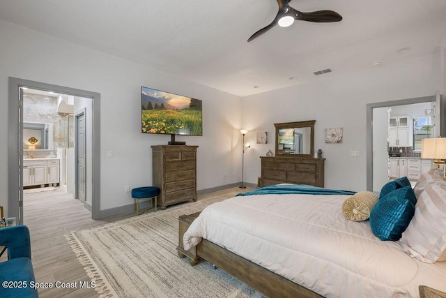 bedroom featuring ceiling fan, light hardwood / wood-style floors, and ensuite bath