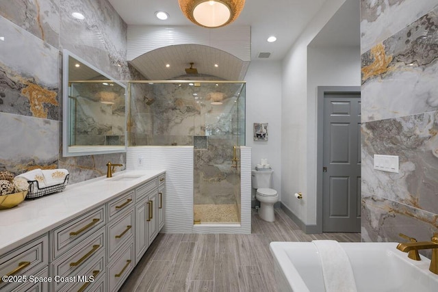 bathroom featuring toilet, tile walls, an enclosed shower, and vanity