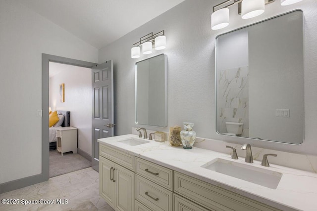 bathroom with toilet, vaulted ceiling, and vanity