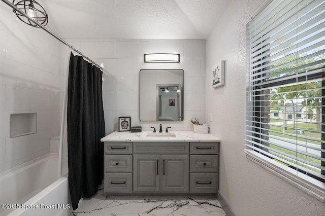 bathroom featuring a textured ceiling, shower / bath combo, and vanity